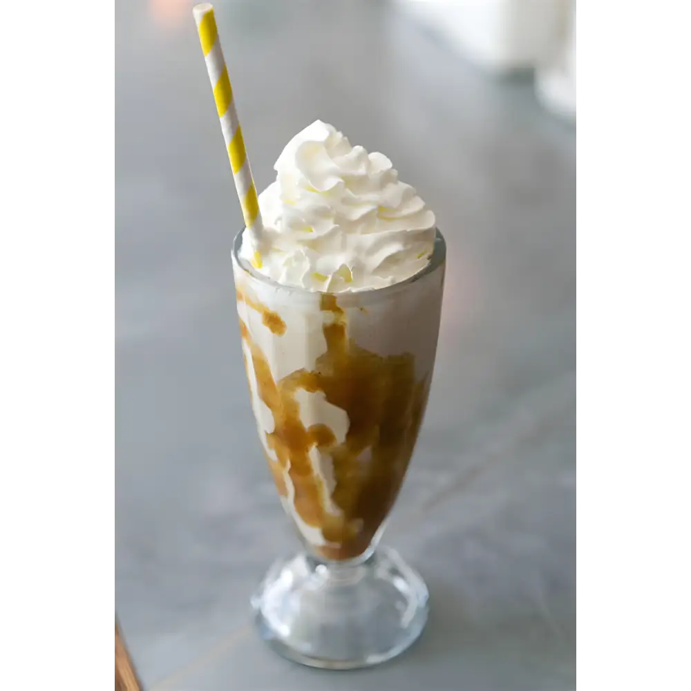 Batido De Caramelo En Mezcla Base neutra Sundae con crema batida y paja de rayas amarillas